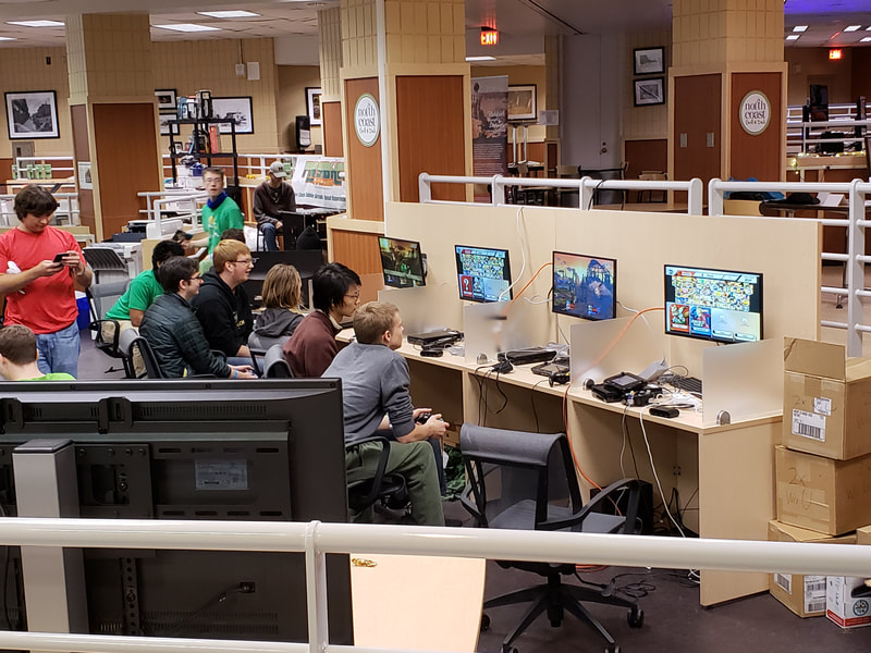 Participants playing video games at stations during the 2018 GeekU.P.